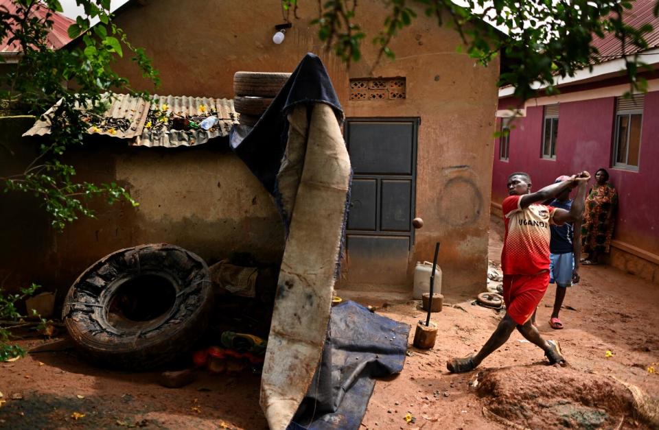 Dennis Kasumba practices his swing during his daily morning workout outside his home.