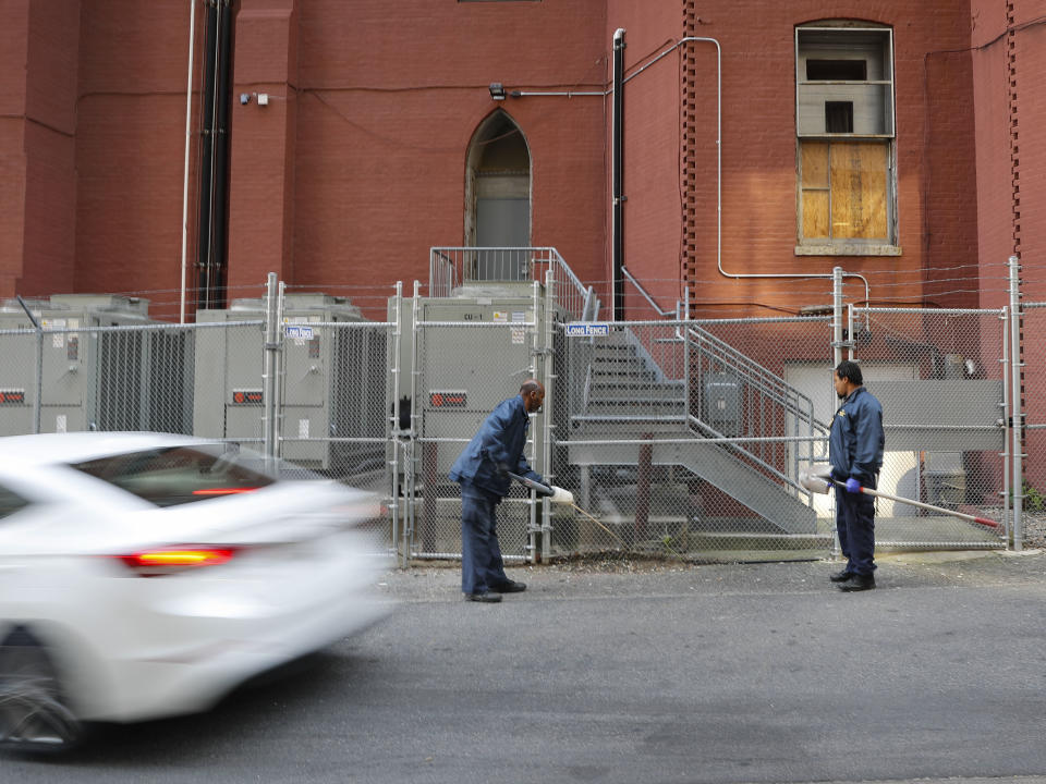 Pest Control Officers Gregory Cornes, center, and Andre Pitman, right, both from the D.C. Department of Health's Rodent Control Division, apply poison into rat burrows, found in the alley behind the Metropolitan African Methodist Episcopal Church in downtown Washington, Wednesday, Oct. 17, 2019. Cornes will pump poison into the burrows and this powder will stick to the paws and fur, when the rats groom themselves, they unwittingly ingest it and die.The nation’s capital is facing a spiraling rat infestation, fueled by mild winters and a human population boom. Washington’s government is struggling to keep pace (AP Photo/Pablo Martinez Monsivais)