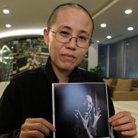 Liu Xia, the wife of Chinese dissident Liu Xiaobo, holds a photo of her husband during an interview in Beijing in 2010 - Credit: Reuters