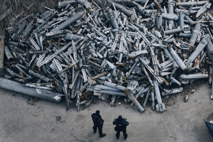 Police officers look at collected fragments of the Russian rockets that hit Kharkiv, in Kharkiv, Ukraine, Saturday, Dec. 3, 2022. (AP Photo/Libkos)