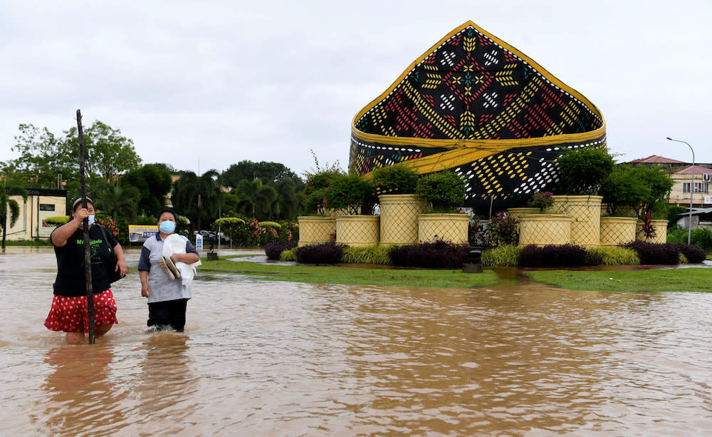 Residents from Pekan Donggongon Penampang wade in flood waters caused by continuous heavy rainfall, January 17, 2021. — Bernama pic