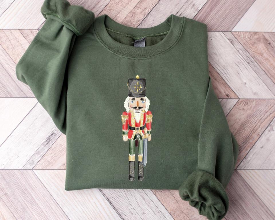 <p><a href="https://go.redirectingat.com?id=74968X1596630&url=https%3A%2F%2Fwww.etsy.com%2Flisting%2F1100734382%2Fnutcracker-sweatshirt-christmas-sweater&sref=https%3A%2F%2Fwww.thepioneerwoman.com%2Ffashion-style%2Fg37501791%2Fcute-christmas-sweaters%2F" rel="nofollow noopener" target="_blank" data-ylk="slk:Shop Now;elm:context_link;itc:0;sec:content-canvas" class="link ">Shop Now</a></p><p>Nutcracker Sweatshirt</p><p>etsy.com</p><p>$29.24</p><span class="copyright">Etsy </span>