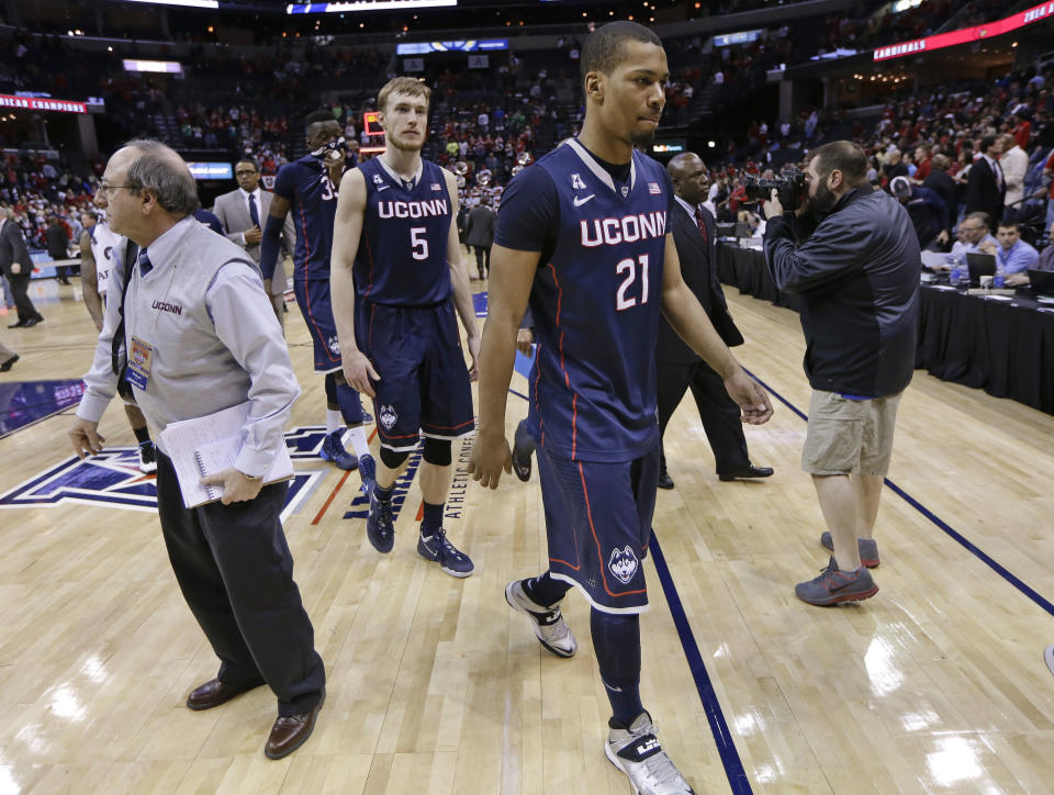 Connecticut's Omar Calhoun (21) and Niels Giffey (5) leave the court after Louisville's 71-61 win in an NCAA college basketball game in the finals of the American Athletic Conference tournament Saturday, March 15, 2014, in Memphis, Tenn. (AP Photo/Mark Humphrey)
