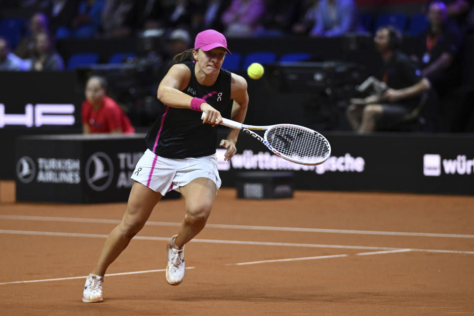 Poland's Iga Swiatek tries to return the ball against Kazakhstan's Elena Rybakina during their semifinal match of the WTA Tour against, in Stuttgart, Germany, Saturday April 20, 2024. (Marijan Murat/dpa via AP)