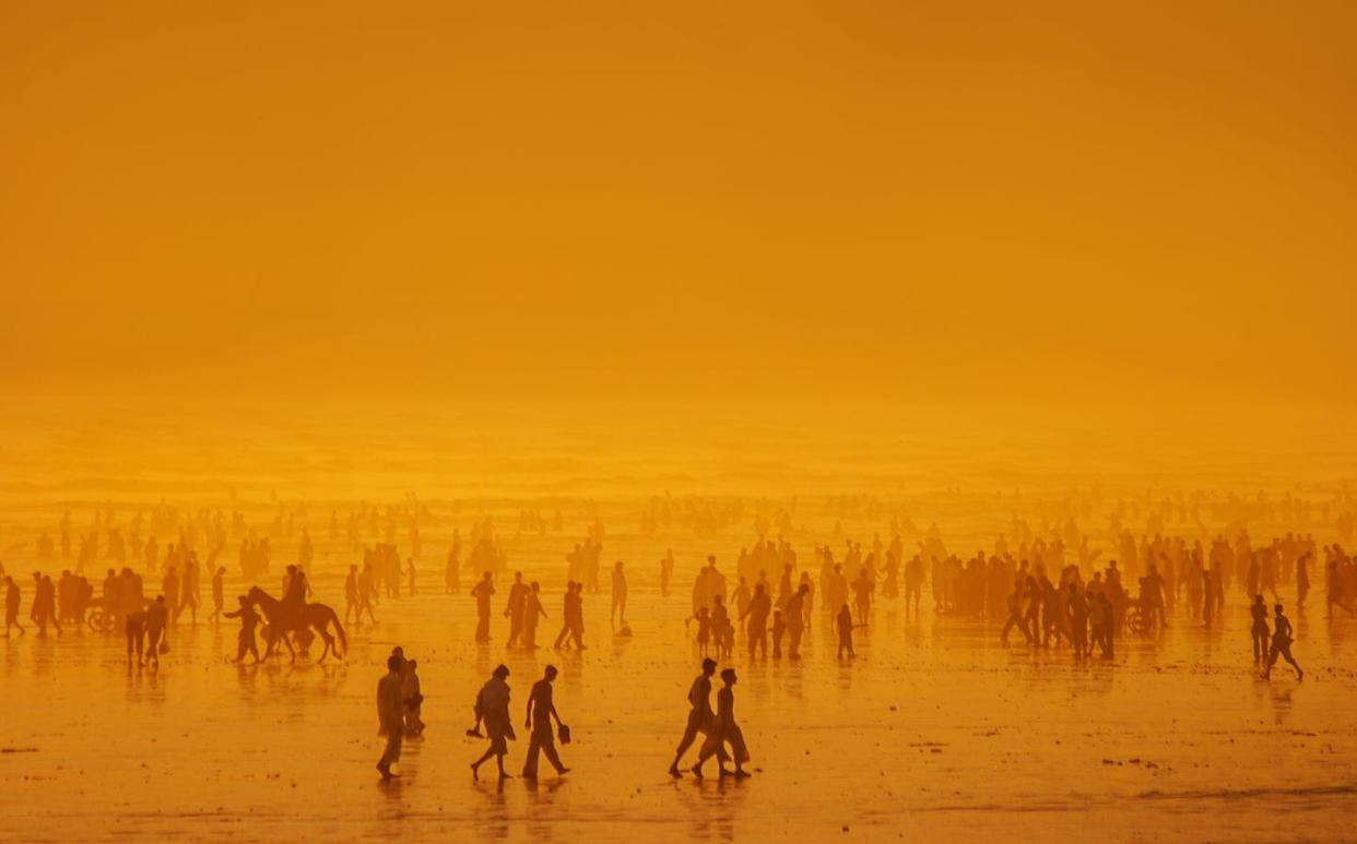 <span class="caption">The ocean retains heat for much longer than land does. </span> <span class="attribution"><a class="link " href="https://www.gettyimages.com/detail/photo/crowded-sunset-silhouette-royalty-free-image/1179557108" rel="nofollow noopener" target="_blank" data-ylk="slk:Aliraza Khatri's Photography via Getty Images;elm:context_link;itc:0;sec:content-canvas">Aliraza Khatri's Photography via Getty Images</a></span>