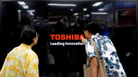 FILE PHOTO: Shoppers look at Toshiba Corp's Regza television at an electronics store in Yokohama, south of Tokyo, June 25, 2013. REUTERS/Toru Hanai/File Photo