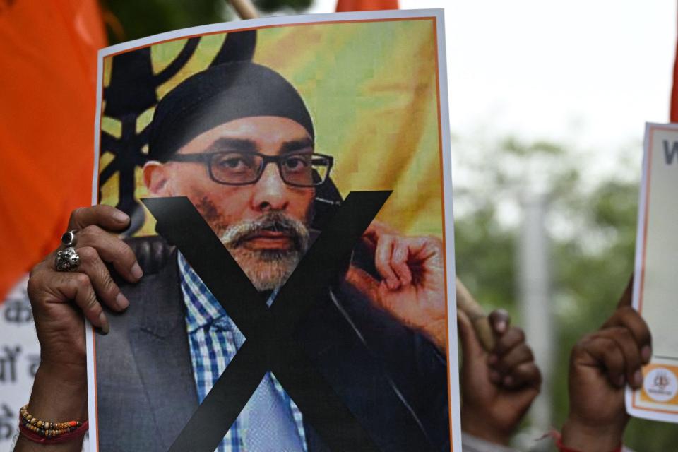 A member of the United Hindu Front organization holds a banner depicting Gurpatwant Singh Pannun, a lawyer and activist designated as a terrorist by the Indian government, during a protest in New Delhi, India, Sept. 24, 2023. / Credit: ARUN SANKAR/AFP/Getty