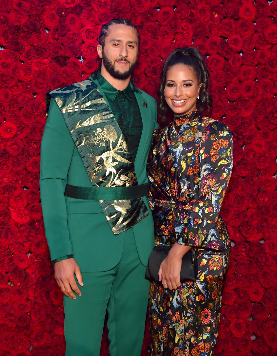 the two posing in front of a rose covered wall