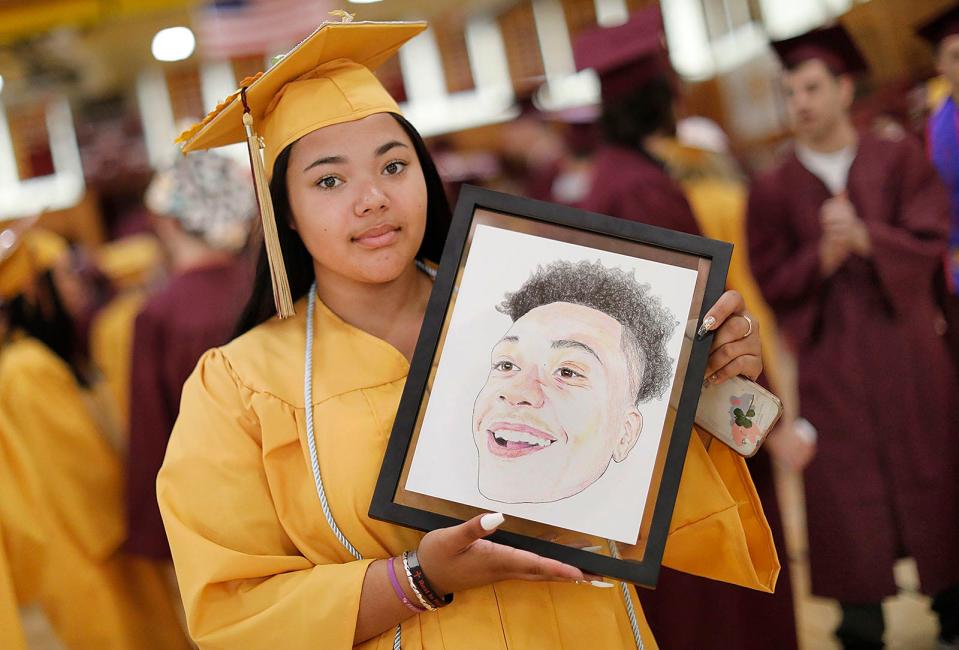 Kelcie Barrow holds a framed drawing of her friend Nathan Paul, who was killed during the school year, at Weymouth High's graduation Saturday, June 4, 2022.