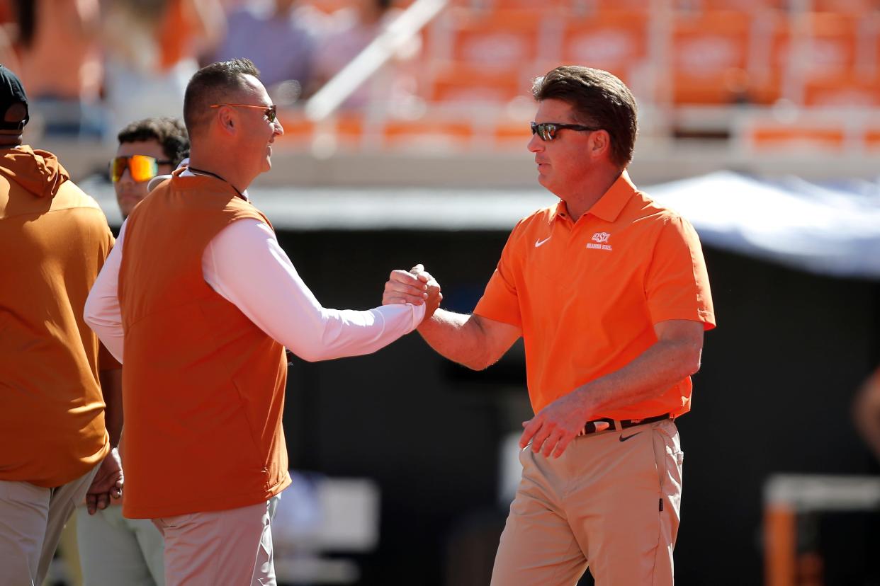Texas Longhorns head coach Steve Sarkisian, left, and Oklahoma State Cowboys head coach Mike Gundy talk before a college football game between the Oklahoma State Cowboys (OSU) and the University of Texas Longhorns at Boone Pickens Stadium in Stillwater, Okla., Saturday, Oct. 22, 2022.  