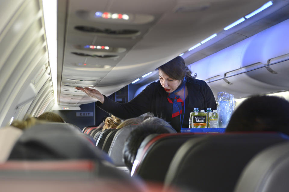 DALLAS, TEXAS - DECEMBER 12, 2018: An American Airlines flight attendant serves drinks to passengers after departing  Dallas/Fort Worth International Airport. (Photo by Robert Alexander/Getty Images)