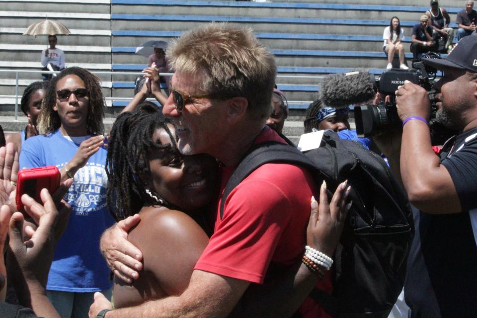 Pine Forest track and field coach Paul Bryan (right) hugs a former athlete during a surprise ceremony at the Escambia County Championships on Saturday, April 13, 2024, at Booker T. Washington High School.