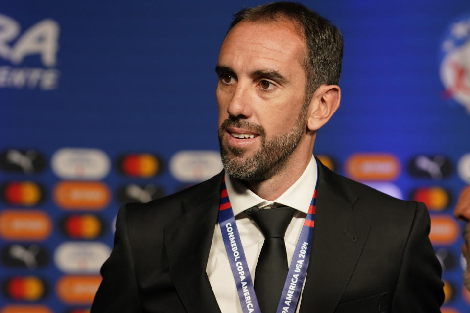 Uruguay's former soccer player Diego Godin talks to journalists as he arrives to the draw ceremony for the Copa America soccer tournament, Thursday, Dec. 7, 2023, in Miami. The 16-nation tournament will be played in 14 U.S. cities starting with Argentina's opener in Atlanta on June 20, 2024. (AP Photo/Lynne Sladky)