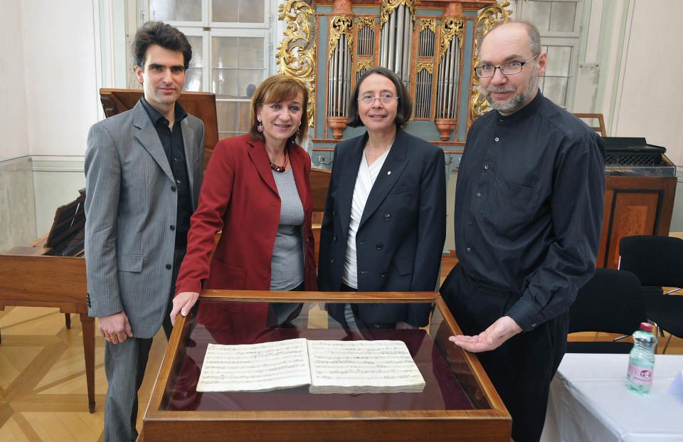 Pianist Florian Birsack, Beate Palrader, member of the provincial government of Tyrol, Music scholar Hildegard Herrmann-Schneider and Urlich Leisinger, leader of the of the International Mozarteum Foundation in Salzburg present sheets of music, recently identified as a composition by Wolfgang Amadeus Mozart, during a press conference held by the research department of the International Mozarteum Foundation in Salzburg, Austria, Friday, March 23, 2012. The previously unknown piano piece from Mozart was discovered in Tyrol in Austria. The Mozart Foundation in Salzburg says that the piece was found in a hand written music book from 1780. (AP Photo/ Kerstin Joensson)