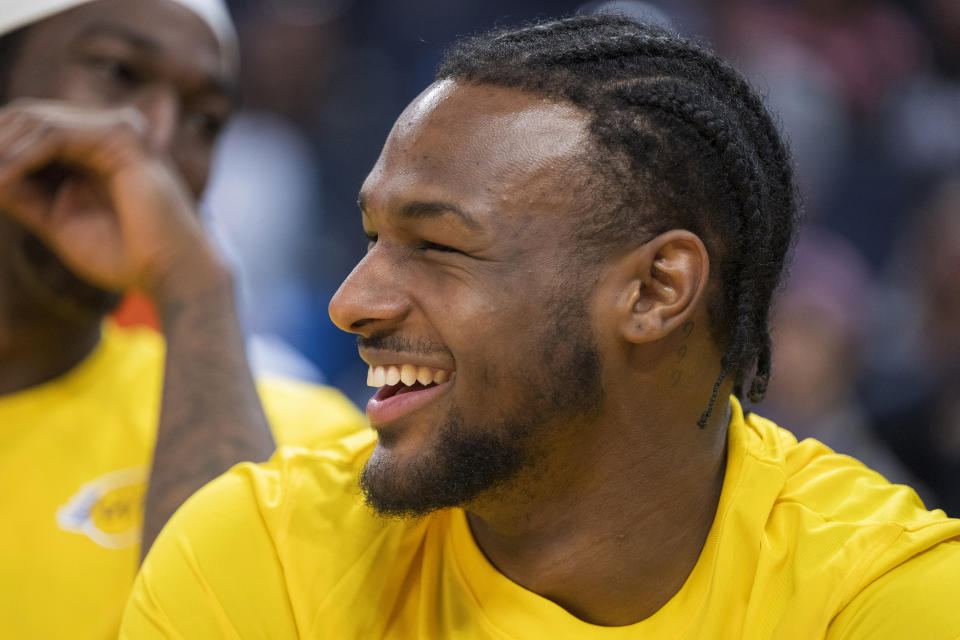 Los Angeles Lakers guard Bronny James laughs with teammates while sitting on the bench during the second half of an NBA summer league basketball game against the Golden State Warriors in San Francisco, Sunday, July 7, 2024. (AP Photo/Nic Coury)