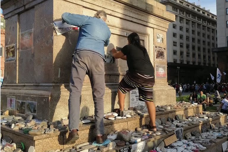 Dos personas arrancan fotos de las víctimas