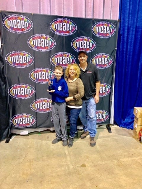 Hillary and Roman Sobilo cheer their son, Keegan, at the Muscle Car and Corvette Nationals on Nov. 23, 2019, in Rosemont, Ill.