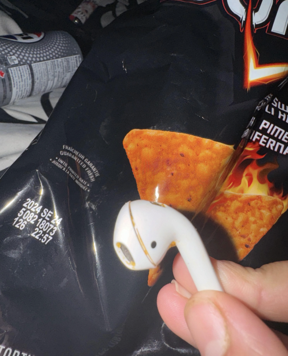 A bag of Doritos chips with a single AirPod in the foreground