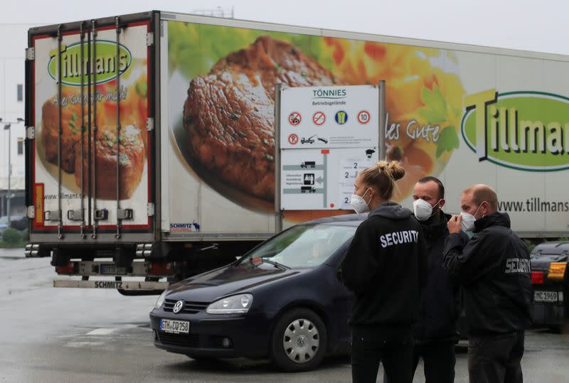 FILE PHOTO: Security personell stands in front of a meat truck as the Toennies meat factory is reopening in Rheda-Wiedenbrueck