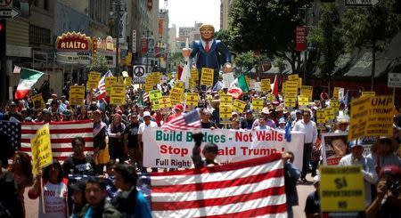 People march with an inflatable effigy of Republican presidential candidate Donald Trump during an immigrant rights May Day rally in Los Angeles, California, U.S., May 1, 2016. REUTERS/Lucy Nicholson