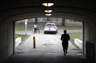 A Chicago police officer notifies a cyclist that the trails along Lake Michigan are closed in an effort to limit the spread of COVID-19 infections, Thursday, March 26, 2020, in Chicago. The new coronavirus causes mild or moderate symptoms for most people, but for some, especially older adults and people with existing health problems, it can cause more severe illness or death. (AP Photo/Charles Rex Arbogast)