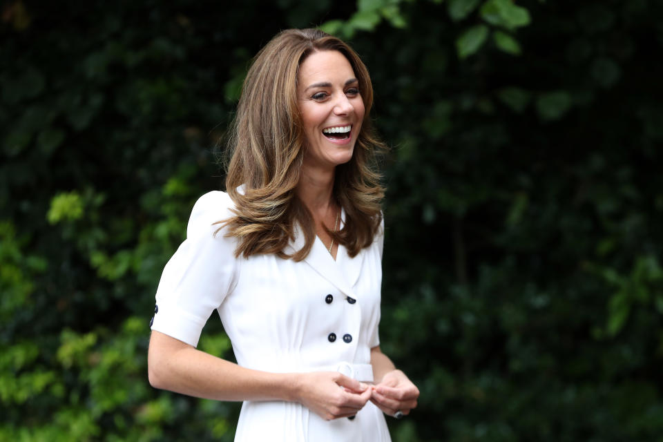 Britain's Catherine, Duchess of Cambridge wears a white dress and laughs as she arrives at Baby Basics baby bank in Sheffield, northern England on August 4, 2020