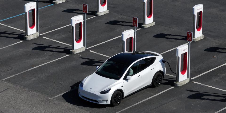 A Tesla car charges on a Tesla Supercharger.