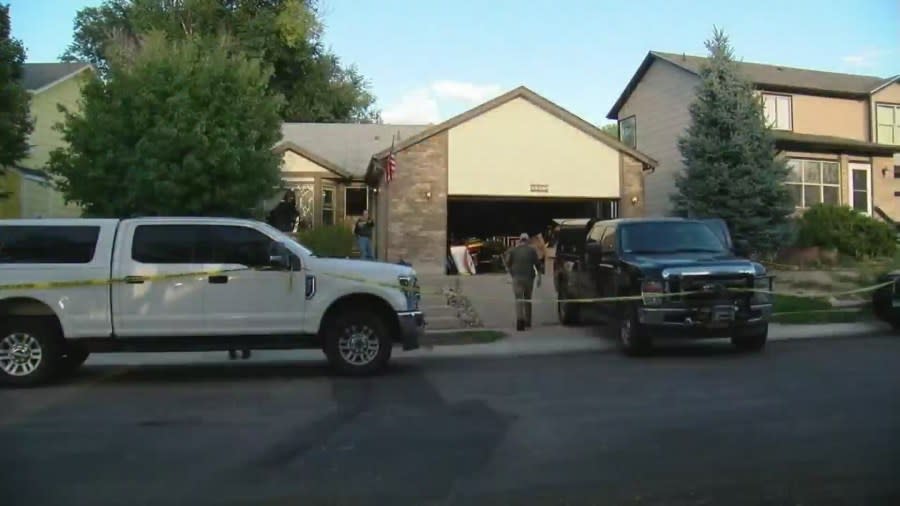 Federal agents search the garage of a home in a neighborhood during the day