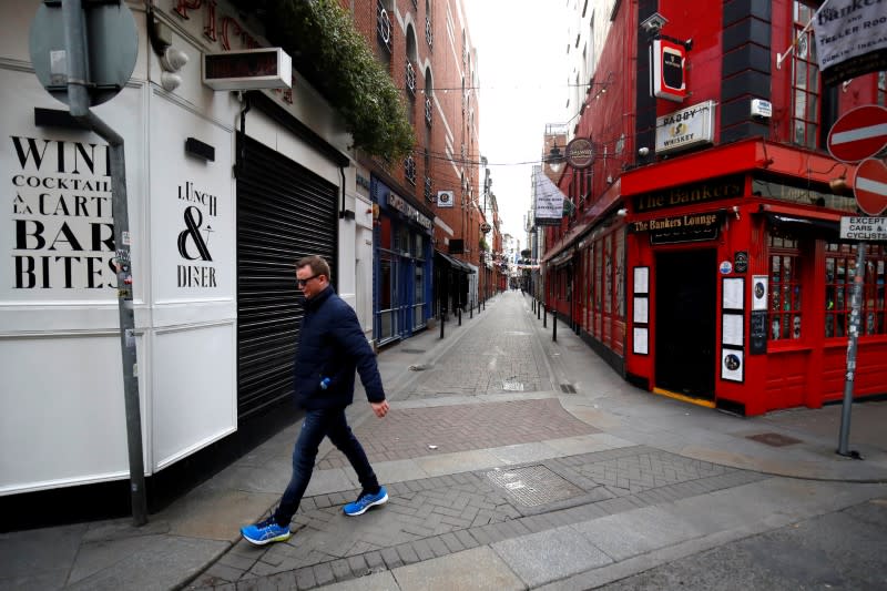 FILE PHOTO: A man walks past a pub in Dublin on St. Patrick's Day as public events were cancelled as the number of coronavirus cases grow around the world