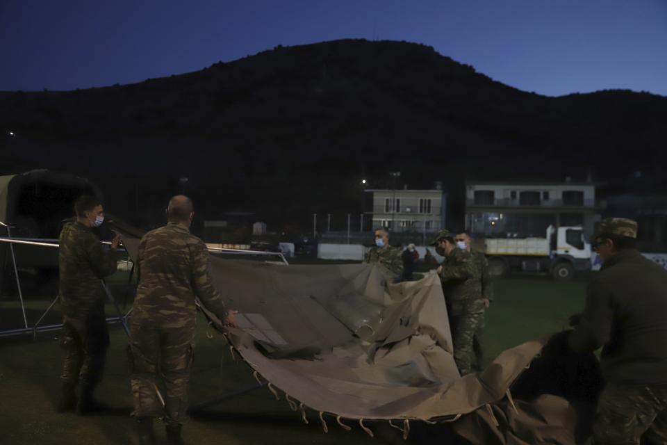 Greek Army set up a tent after an earthquake in Damasi village, central Greece, Wednesday, March 3, 2021. An earthquake with a preliminary magnitude of at least 6.0 struck central Greece Wednesday and was also felt in neighboring Albania and North Macedonia, and as far as Kosovo and Montenegro. (AP Photo/Vaggelis Kousioras)