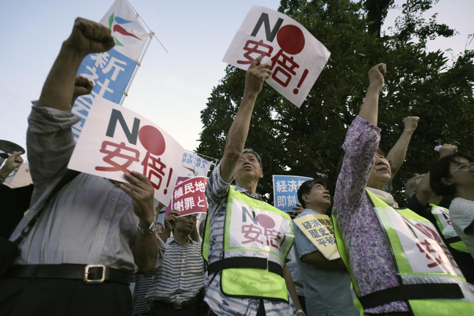 Protesters with "No Abe!" signs chat slogans during a rally outside Japanese Prime Minister Shinzo Abe's residence in Tokyo Thursday, Aug. 8, 2019. More than 100 people staged a rally to urge the government to reverse the recent downgrading of South Korea's trade status and to apologize for wartime atrocities in an effort fix rapidly souring relations. (AP Photo/Eugene Hoshiko)