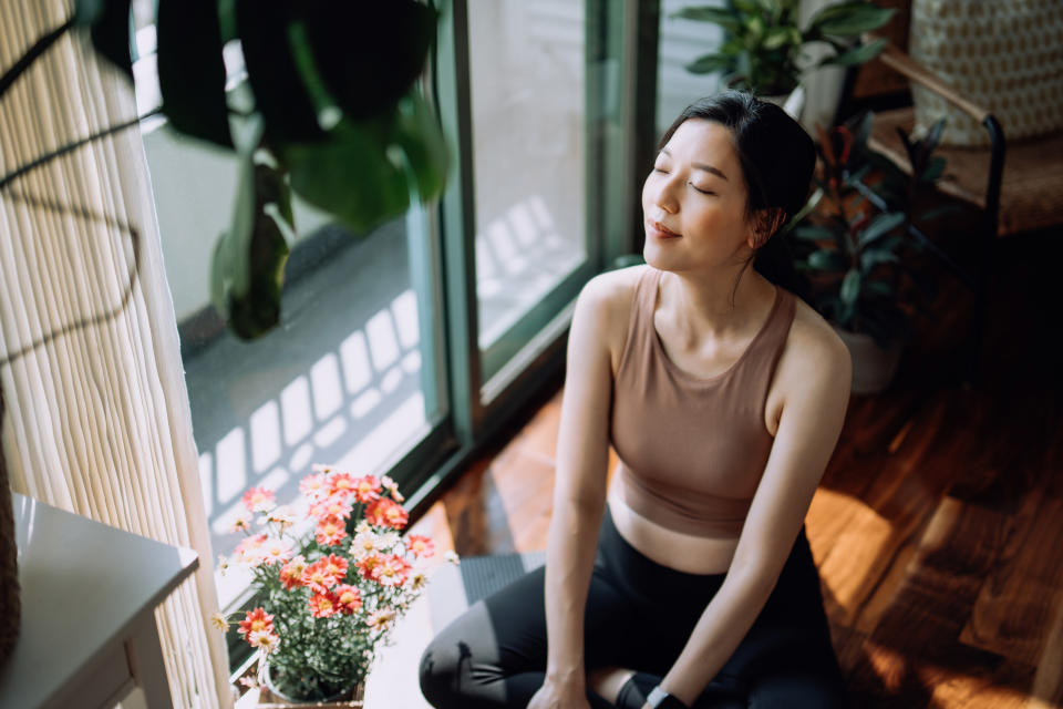 a woman meditating in her home