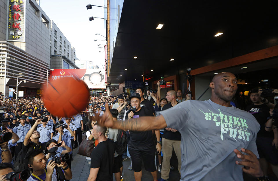 NBA star Kobe Bryant throws a ball to his fans during a promotional event in a shopping district in China's southern city of Shenzhen, Sunday Aug. 4, 2013. Kobe Bryant visited Shenzhen as part of his China tour. (AP Photo/Kin Cheung)