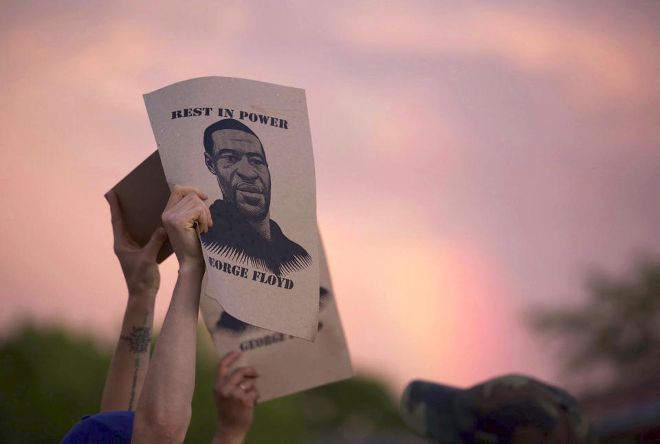 A protester holds a sign with an image of George Floyd during protests on May 27, 2020, in Minneapolis. (Christine T. Nguyen / Minnesota Public Radio via AP file)