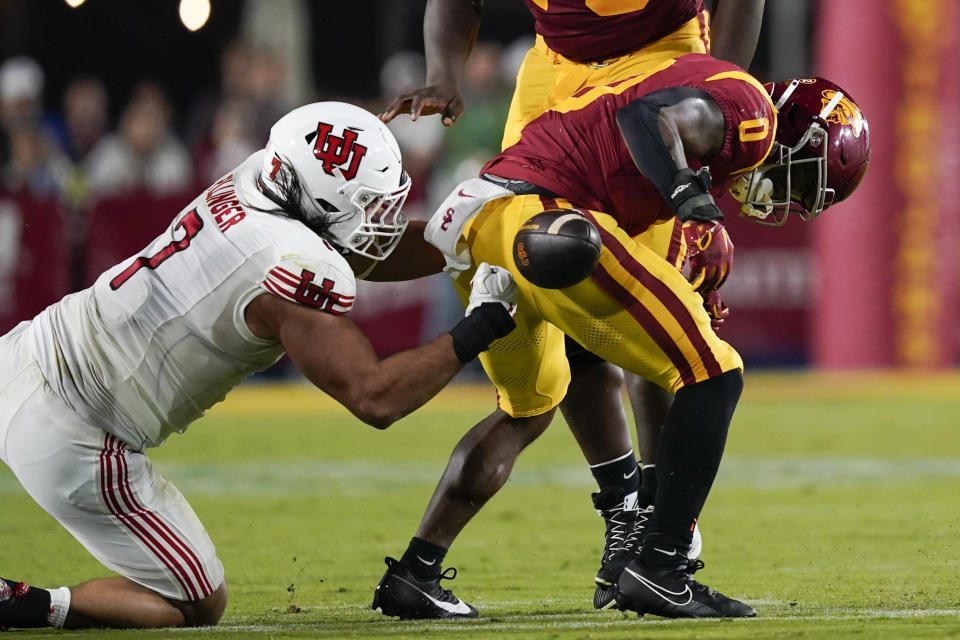 Southern California running back MarShawn Lloyd, right, fumbles the ball after being tackled by Utah defensive end Van Fillinger, left, during the second half of an NCAA college football game, Saturday, Oct. 21, 2023, in Los Angeles. (AP Photo/Ryan Sun)