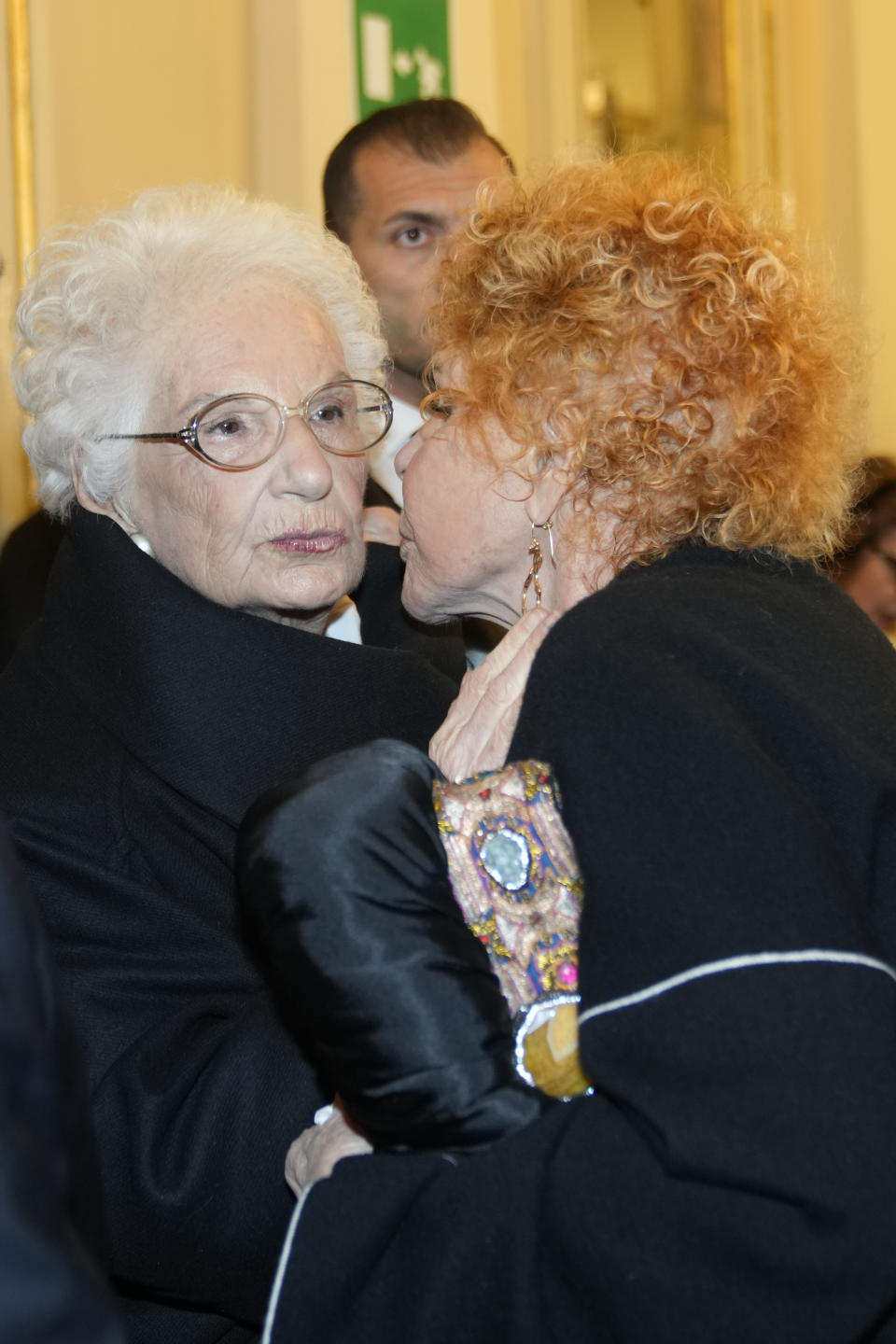 Italian Senator Liliana Segre, left, is greeted by Italian singer Ornella Vanoni as she arrives to attend La Scala opera house's gala season opener, Giuseppe Verdi's opera 'Don Carlo' at the Milan La Scala theater, Italy, Thursday Dec. 7, 2023. The season-opener Thursday, held each year on the Milan feast day St. Ambrose, is considered one of the highlights of the European cultural calendar. (AP Photo/Luca Bruno)