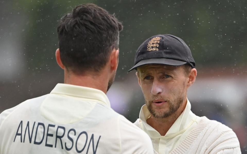 England's captain Joe Root (R) stands talking with England's James Anderson as players leave the field for a rain delay on the third day of the first cricket Test match of the India Tour of England 2021 between England and India at the Trent Bridge cricket ground in Nottingham, central England, on August 6, 2021 - GETTY IMAGES