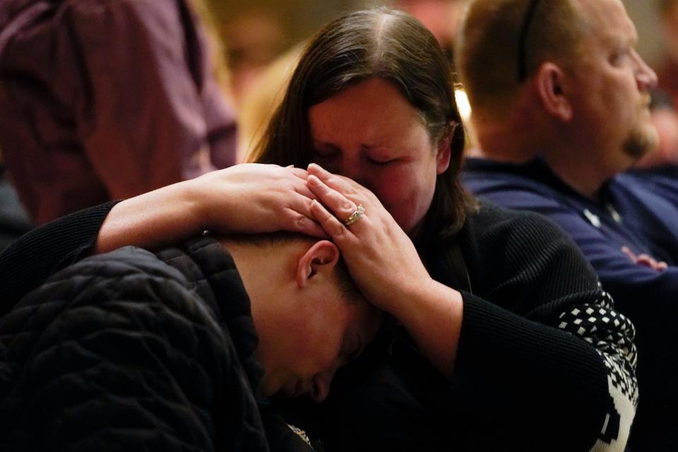 Aiden Watson, who was injured at Oxford High School, attends a vigil with his mother at LakePoint Community Church in Oxford, Mich., late Tuesday, Nov. 30, 2021. Authorities say a 15-year-old sophomore opened fire at Oxford High School, killing three students and wounding several others, including a teacher. (AP Photo/Paul Sancya)