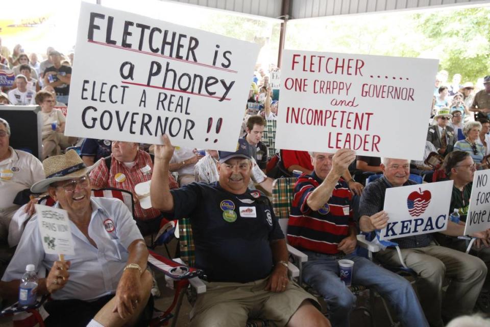 Steve Beshear supporters Jay Lathem and Fluff (cq) Hudson held up signs at the annual Fancy Farm political picnic held at the St. Jerome Catholic Church in Fancy Farm, Ky., Saturday, August 4, 2007. Photo by Charles Bertram | Staff. 3699