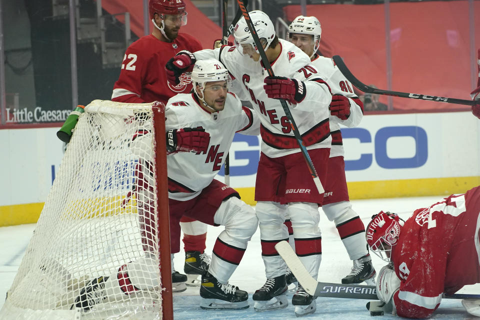 Carolina Hurricanes right wing Nino Niederreiter (21) celebrates his goal with Sebastian Aho (20) as Detroit Red Wings goaltender Thomas Greiss (29) looks at the puck in the first period of an NHL hockey game Thursday, Jan. 14, 2021, in Detroit. (AP Photo/Paul Sancya)