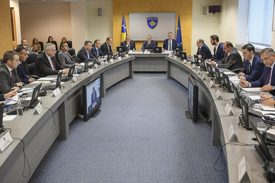 In this photo provided by the Kosovo government public affairs office, showing Kosovo Prime Minister Ramush Haradinaj, center, flanked by his cabinet during the government meeting on Wednesday, Nov. 21, 2018, in Kosovo capital Pristina. Kosovo's government has decided to introduce a 100 percent import tax on all goods imported from Serbia and Bosnia Herzegovina. (Kosovo Government via AP)