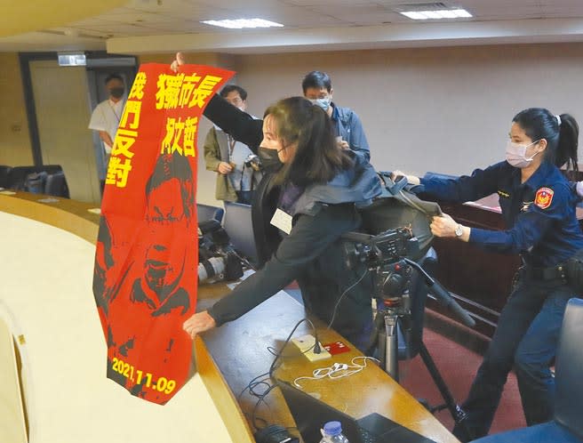 台北市議會19日市政總質詢時，突然有社子島居民手持海報衝進記者室，抗議正在議場答詢的市長柯文哲，駐衛警也立刻上前制止。（鄭任南攝）