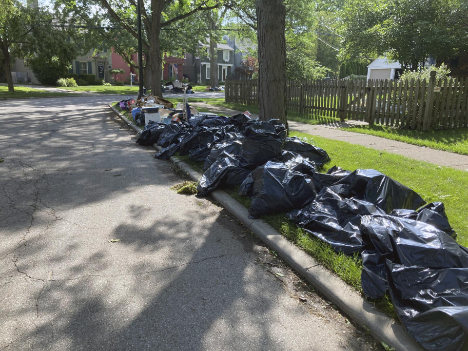 Trash is shown on a street in Grosse Point Farms, Mich., Sunday, June 27, 2021. Residents in the Detroit area were cleaning up Sunday after flooding in the area overloaded sewer systems, damaged homes and knocked out power for thousands. (AP Photo/Ed White)