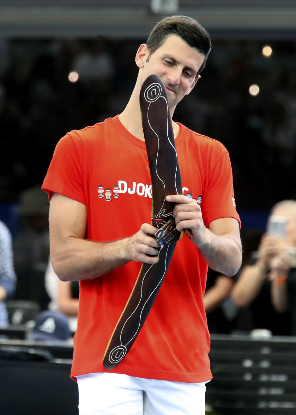 Serbia's Novak Djokovic receives an aboriginal boomerang prior to playing in an exhibition tennis event in Adelaide, Australia, Friday, Jan. 29. 2021. (Kelly Barnes/AAP Image via AP)