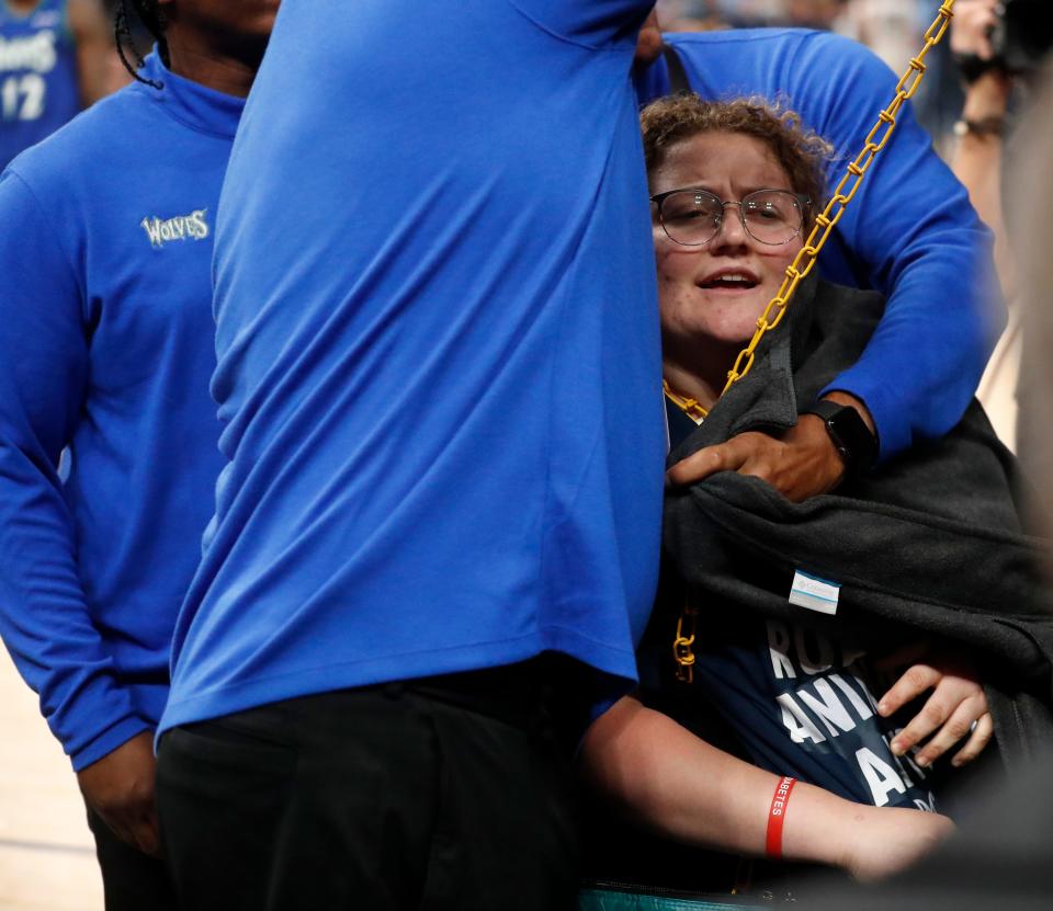 A protester chains herself to the basket during the first half of the Grizzlies-Wolves game in Memphis.