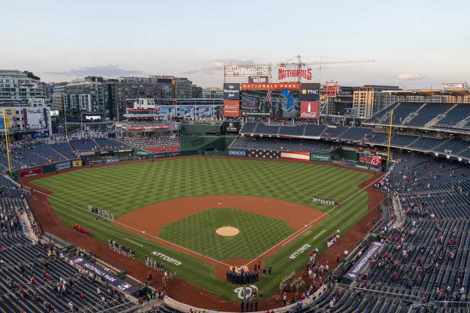 The sun sets over Nationals Park in Washington as the Chicago White Sox and the Washington Nationals stand at attention during the singing of the national anthem before a baseball game, Monday, Sept. 18, 2023. (AP Photo/Stephanie Scarbrough)