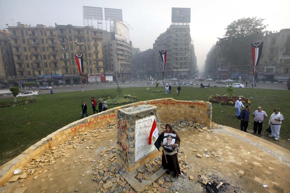 FILE - In this Tuesday, Nov. 19, 2013 file photo, a woman holds a poster of Egyptian Defense Minister Gen. Abdel-Fattah el-Sissi with an Arabic that reads, "we authorize you," as she stands at the foundation for a future memorial to protesters killed in the country's uprising more than two-and-a-half years of turmoil, after it was damaged in Tahrir Square, Cairo, Egypt. Egypt's military chief is looking for a strong turnout in next week's nationwide constitutional referendum as a mandate on whether he should run for president, senior officials tell the AP. The popular general who ousted President Mohammed Morsi and ordered a crackdown on the Muslim Brotherhood could be disappointed as his Islamist foes have promised a boycott and mass demonstrations raising fears of violence that are likely to keep voters at home.(AP Photo/Amr Nabil, File)