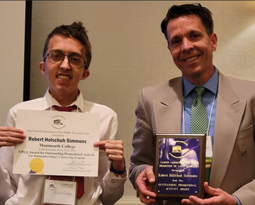 Rahm Pandey ’24 and professor Bob Simmons are pictured with two of the four awards that Monmouth College brought home from the CAMWS meeting. (Monmouth College)