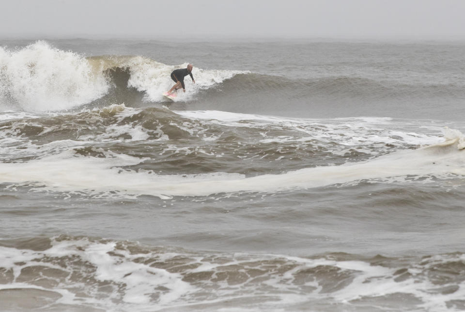 A surfer finds a wave in Mexico Beach, Fla. after Tropical Storm Nestor hit the town on Saturday, Oct. 19, 2019. The storm brought heavy rain and high surf, but did not damage the town severely. (Joshua Boucher/News Herald via AP)
