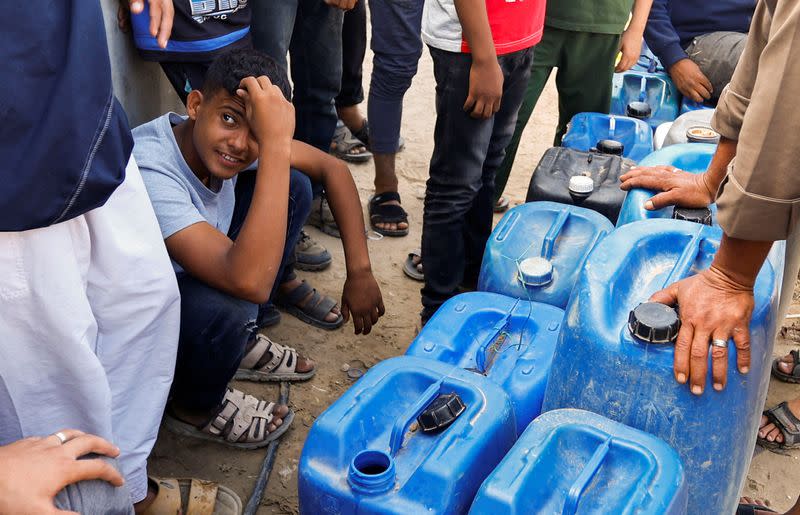 Palestinos recogen agua, en medio de la falta de agua potable y limpia, mientras continúa el conflicto entre Israel y el grupo islamista palestino Hamás, en Rafah, en el sur de la Franja de Gaza